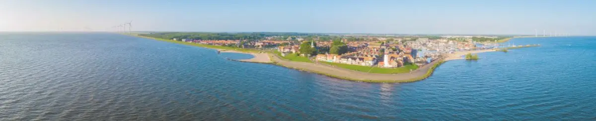 afbeelding genomen met een drone. Op de voorgrond zie je water en daarachter Urk. Je ziet het Urker landschap. Dit is een header afbeelding voor de pagina: vacatures Urk van de website: Werken bij Willem.