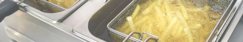 Bijbaan Urk header. Patat in hete olie in een RVS-friteuse